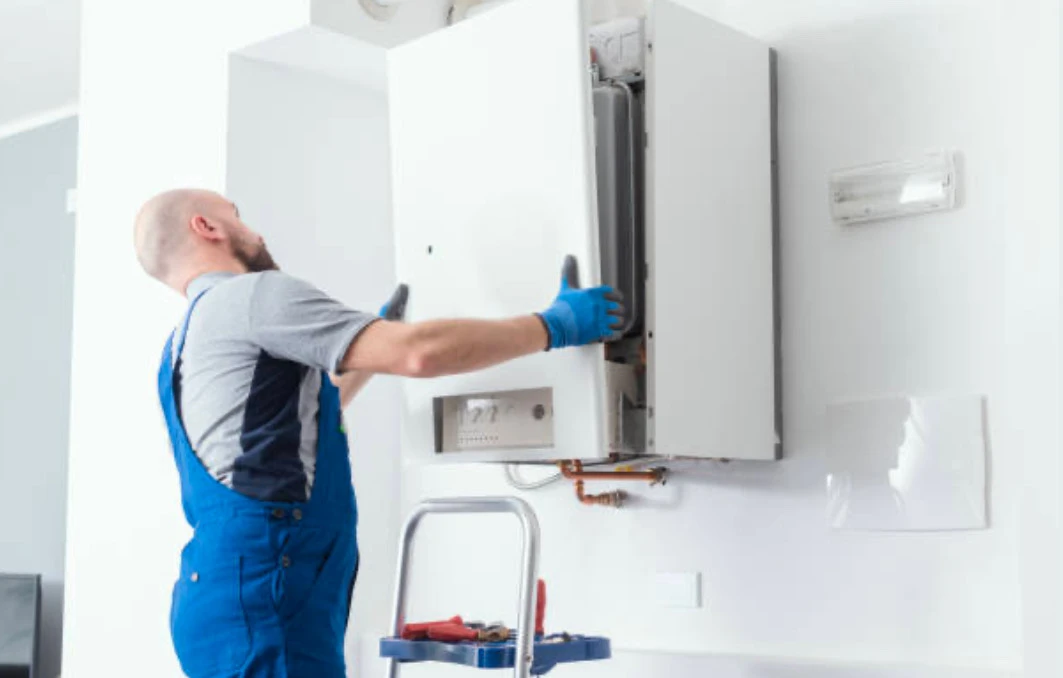 Technicien chauffagiste en pleine installation d’une chaudière pour un client à Carpentras, dans le cadre des services de chauffage proposés par A L’EAU PLOMBIER.